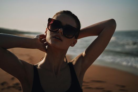 Cheerful woman black swimsuit ocean nature summer tan. High quality photo
