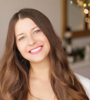 Christmas time and holiday mood concept. Happy smiling woman and decorated xmas tree lights on background.