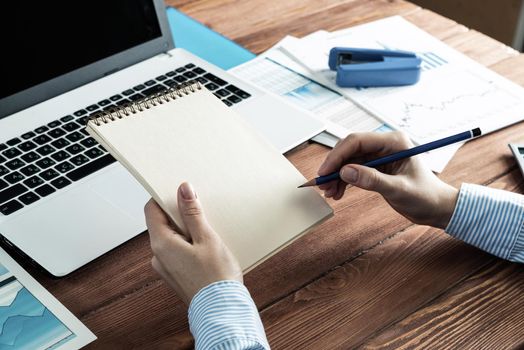 close-up, female hands with notebook and pencil. Business woman working at the table in the office