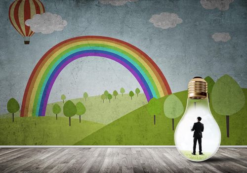Businessman inside light bulb in room against nature drawn concept