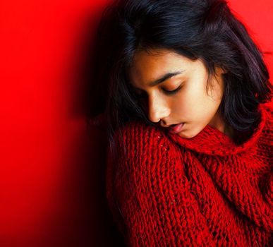 young pretty indian girl in red sweater posing emotional, fashion hipster teenage, lifestyle people concept closeup