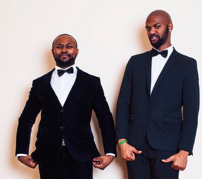 two afro-american businessmen in black suits emotional posing, gesturing, smiling. wearing bow-ties close up