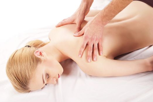 girl getting a massage - hands massaging her back - A pretty woman getting a shoulder and back massage