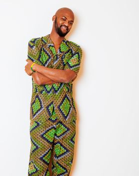 portrait of young handsome african man wearing bright green national costume smiling gesturing, entertainment stuff close up