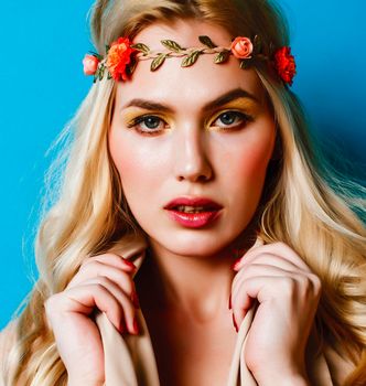 young blond woman dressed like ancient greek godess, beautiful girl hands manicured red nails on blue background copyspace close up