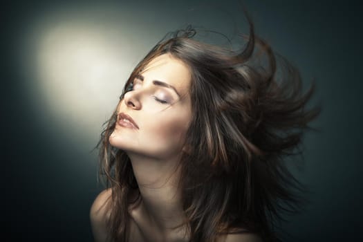 Sensual young woman with beautiful long brown hairs, posing. Studio shot