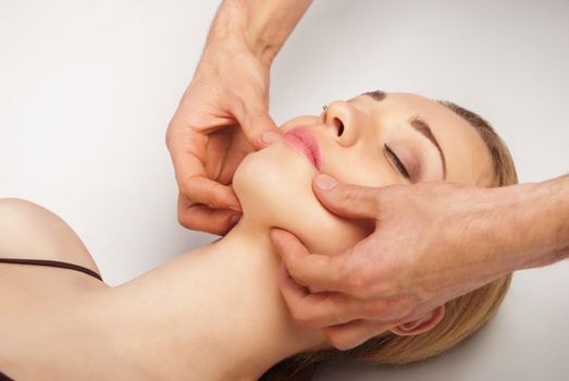 Young bright woman receiving a head massage in a spa centre