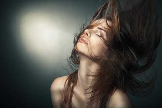 Sensual young woman with beautiful long brown hairs, posing. Studio shot