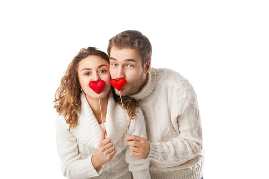 Portrait of joyful couple holding red hearts and laughing isolated on white