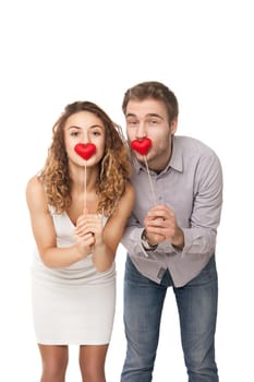 Portrait of joyful couple holding red hearts and laughing isolated on white