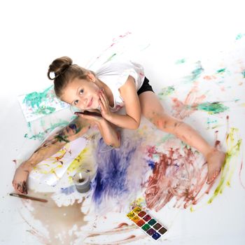 A little girl draws paints on her body. The concept of children's creativity, education and school. Isolated on white background.