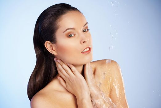 Portrait of young sensuality beautiful woman under the stream of water - blue background