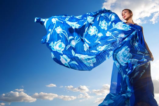 Portrait of a beauty woman in blue dress on the desert