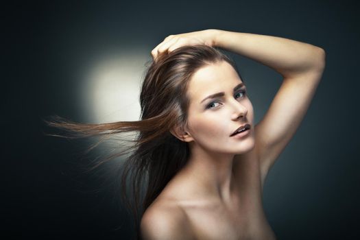 Sensual young woman with beautiful long brown hairs, posing. Studio shot