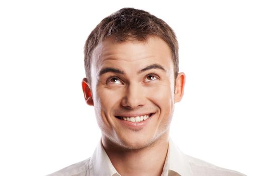 Handsome smiling young man looking up over white background