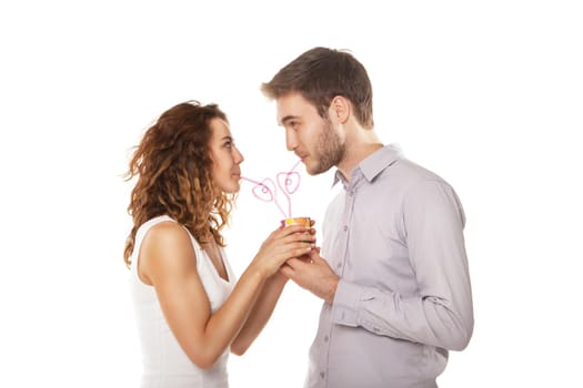 couple in love drink from the same glass isolated on white