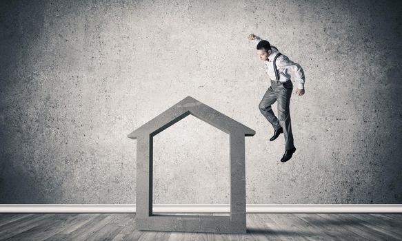 Determined businessman going to break with fist house concrete figure