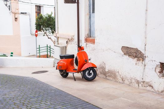 Barcelona, Spain - January 13 , 2018: Orange Scooter Vespa parked on old street in Barcelona, Spain.