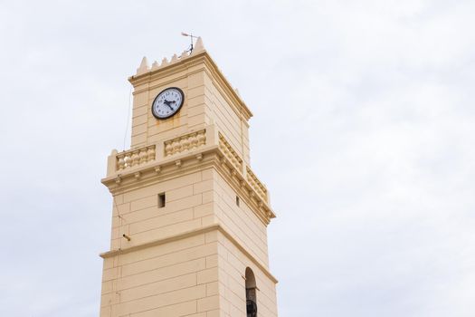 Old clock beige tower in the sky.