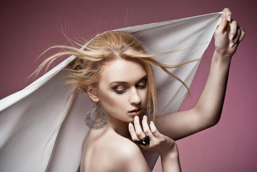 Beautiful portrait of sexy young haughty woman with precious ring and earrings closeup. Studio shot