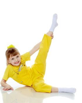 Girl with a short bangs on her head and bright yellow overalls.She crouched down on the white advertising banner.