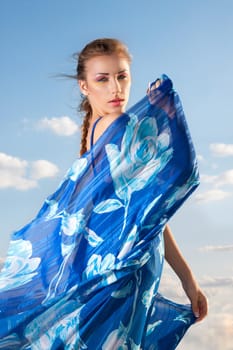 Portrait of a beauty woman in blue dress on the desert