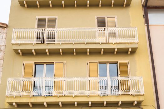 Spanish balconies with white forged openwork fencing.