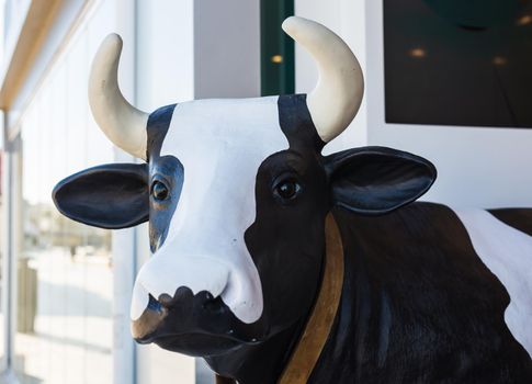 Close up of a cow head statue in front of shop.