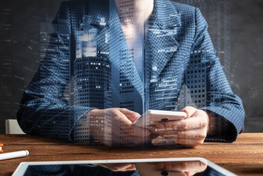 Businesswoman using mobile phone at desk. Close up woman hands and tablet computer. Mobile communication concept with chatting woman. Digital technology in strategy planning and company management