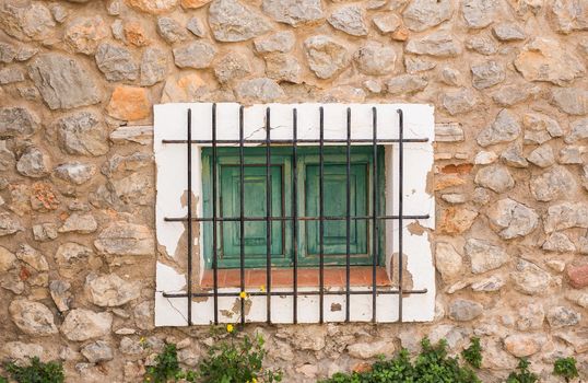 Small window with lattice on the white facade.