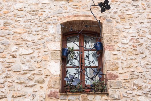 Design, architecture and exterior concept - Beautiful wrought-iron grille in the window on stone wall.