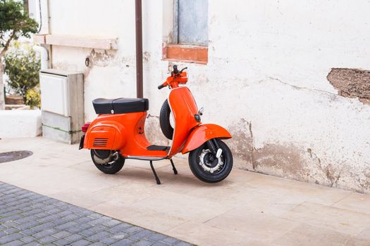 Barcelona, Spain - January 13 , 2018: Orange Scooter Vespa parked on old street in Barcelona, Spain.