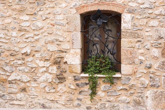 Design, architecture and exterior concept - Beautiful wrought-iron grille in the window on stone wall.