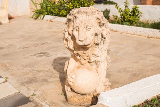 Stone lion statue. Marble Sculpture of a lion on pedestal.