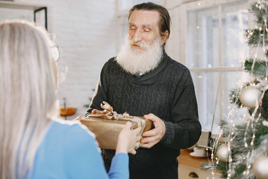 Age and people concept . Senior couple at home. Woman in a blue knited sweater.