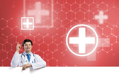 Young handsome doctor holding white blank banner. Place your text