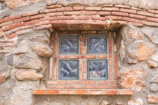 Design, architecture and exterior concept - Old small window on the stone facade.