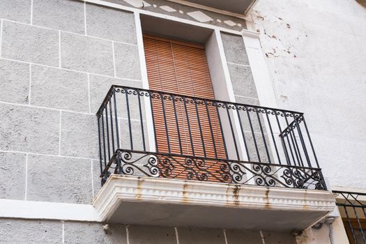 Spanish balcony with black forged openwork fencing.