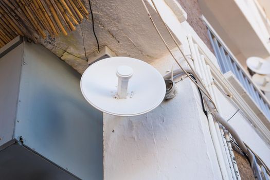 satellite dish and TV antennas on the house roof with blue sky background