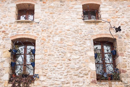 Design, architecture and exterior concept - Beautiful wrought-iron grille in the window on stone wall.