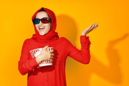 arab woman 3d glasses technology watching movie popcorn yellow background. High quality photo