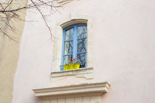 Design, architecture and exterior concept - Blue window with flower pot on the white facade.