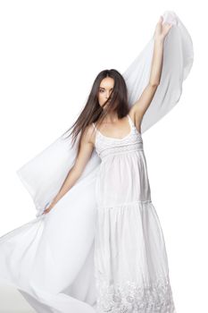 Young woman dancing in gorgeous white dress over white