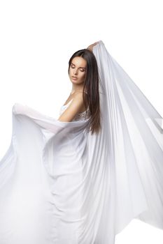 Young woman dancing in gorgeous white dress over white