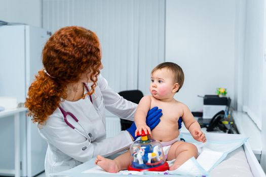 Little girl at doctor for checkup. Doctor pediatrician and baby patient. Child patient at doctor appointment. Pediatrician checking kid's health. Medical examination by a neonotologist doctor of baby.