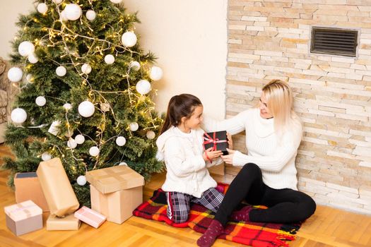Mother giving her daughter christmas gift.