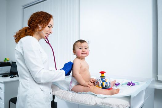 Little girl at doctor for checkup. Doctor pediatrician and baby patient. Child patient at doctor appointment. Pediatrician checking kid's health. Medical examination by a neonotologist doctor of baby.