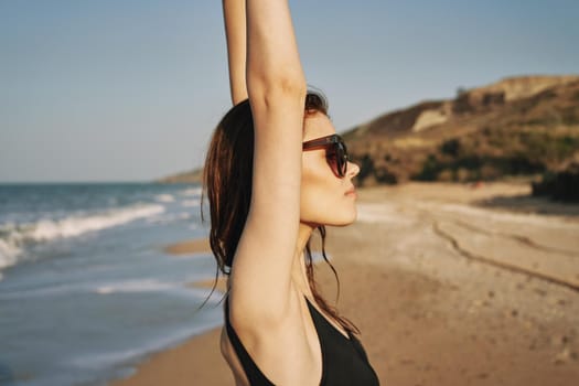 cheerful woman sunglasses posing black swimsuit island. High quality photo