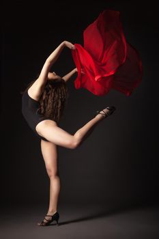 Modern style dancer with red fabric posing on a studio grey background