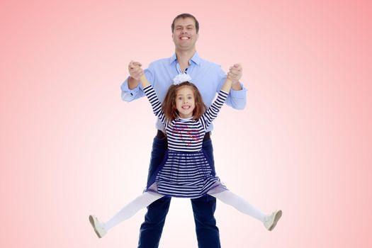 Happy young dad raise his beloved daughter's hands.Pale pink gradient background.